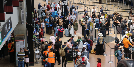 Fotografía de pasajeros  haciendo fila en registro del aeropuerto