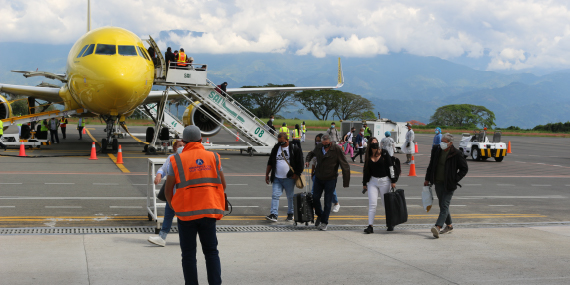 Fotografía de Pasajeros desembarcando de un avión en pista de aeropuerto-100