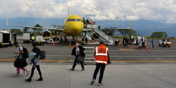 Pasajeros abordando un avión en pista de aeropuerto