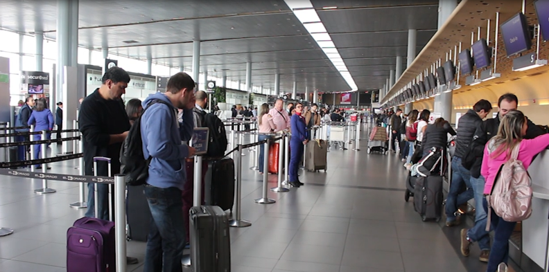 Fotografía de pasajeros en aeropuerto haciendo fila en counter